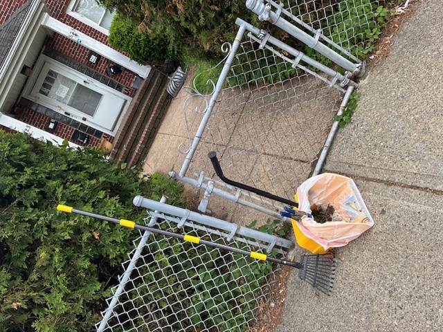 Cabral's cleanup tools and pickup bag at a residential gate