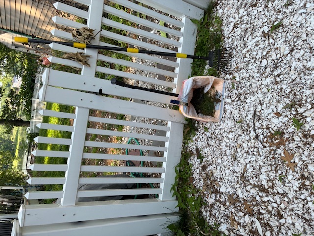 Cabral's cleanup tools by a white picket fence