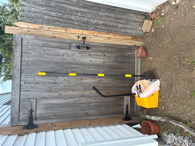 Cabral's pooper scooper tools staged by a wooden gate